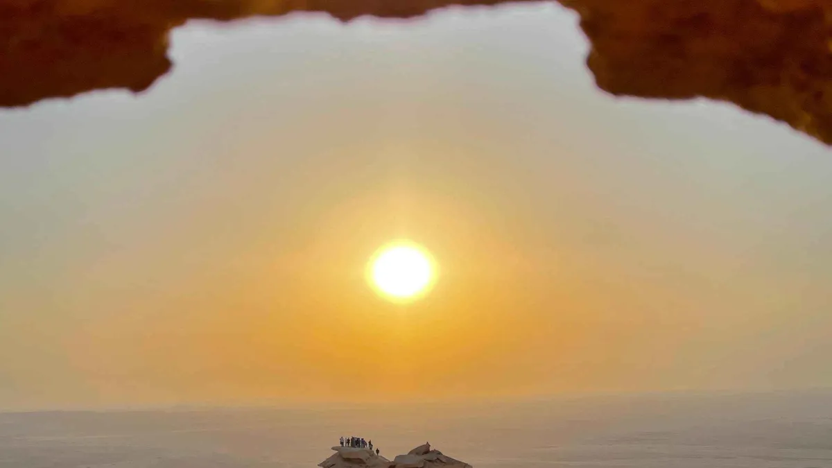Small group watching sunset from the Tuwaiq escarpment on an Edge of the World Riyadh tour near Jebel Fihrayn, Saudi Arabia